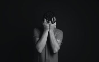 Mężczyzna trzymający ręce na twarzy