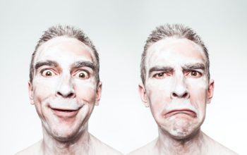 Twarz mężczyzny z mimiką optymisty i pesymisty